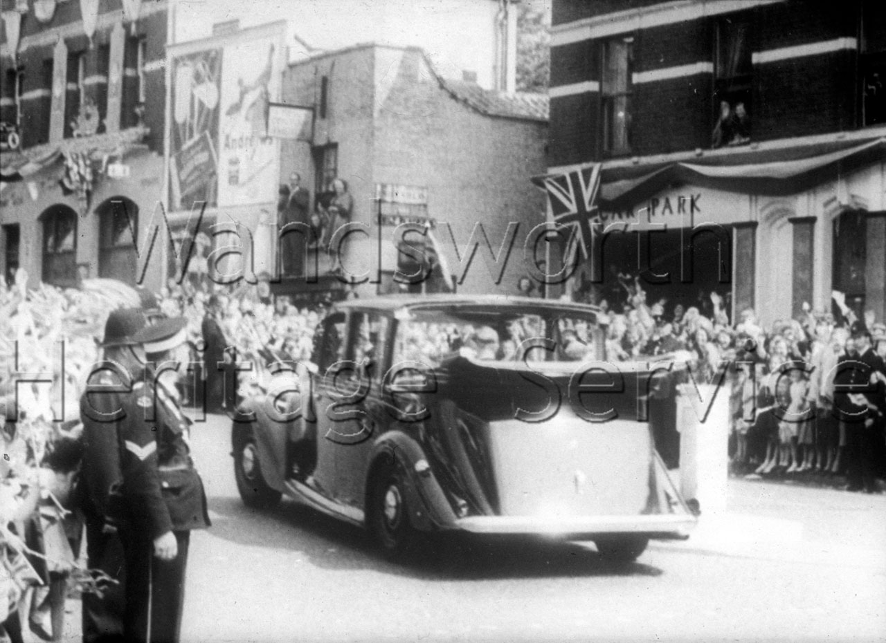 The royal motorcade along a Wandsworth street lined with Union Jacks, 9 June 1953